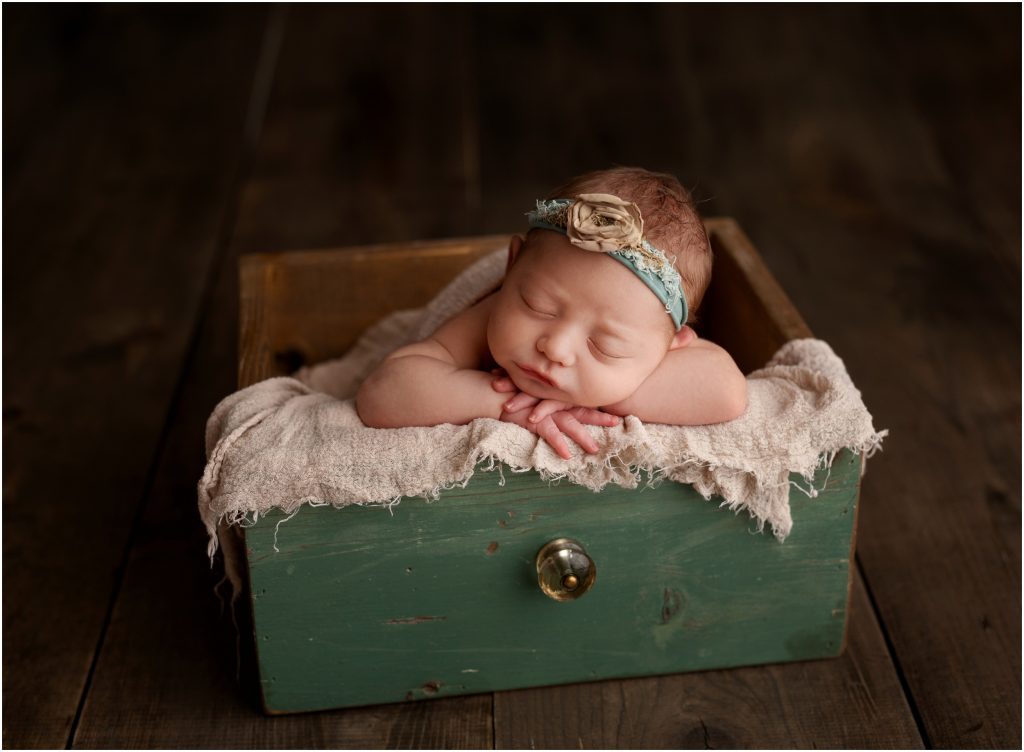 Newborn posed in crate
