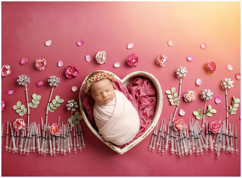 Newborn baby surrounded by IVF needles 